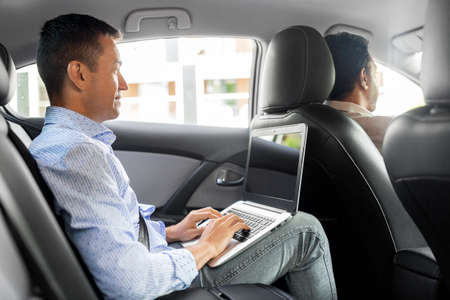 male passenger with laptop computer in taxi car