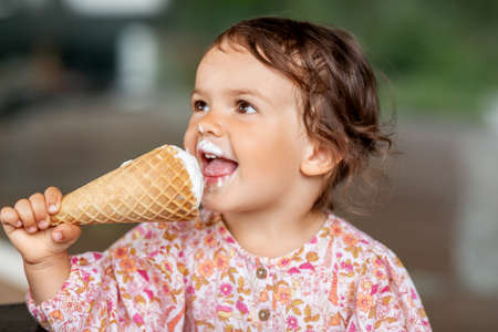 happy little baby girl eating ice cream