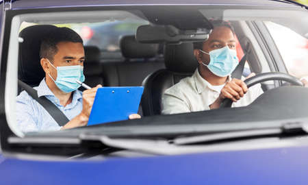 car driving school instructor and driver in mask