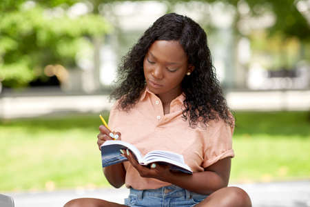 african american student girl making notes in bookの写真素材