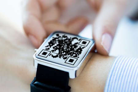 womans hands with qr code on smart watch