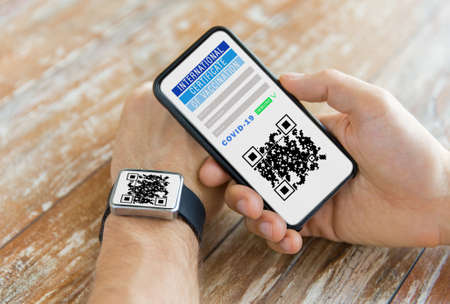 hands with virtual immunity passport on smartphoneの写真素材