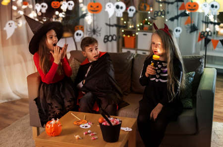 kids in halloween costumes playing at homeの写真素材