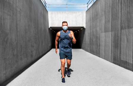 young man in medical mask running outdoorsの写真素材