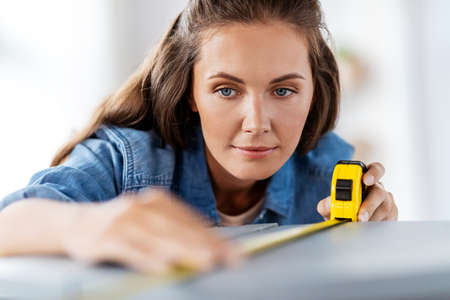 woman with ruler measuring table for renovation