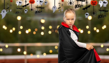 girl in costume of dracula with cape on halloweenの写真素材
