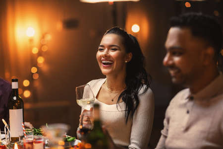 happy friends drinking wine at christmas partyの写真素材