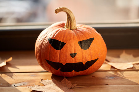 halloween pumpkin and autumn leaves on window sillの写真素材