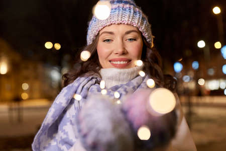 happy young woman holding christmas lights