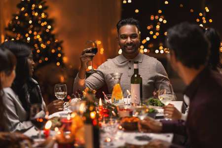happy friends drinking wine at christmas party