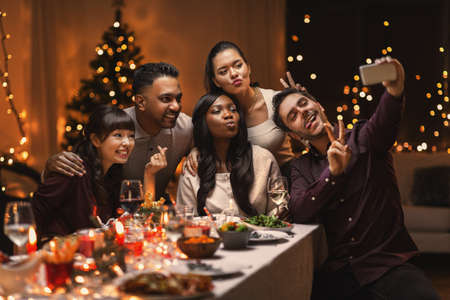 friends taking selfie on christmas dinner at home