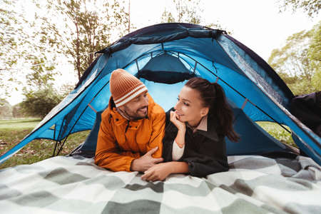happy couple lying inside tent at campsiteの写真素材