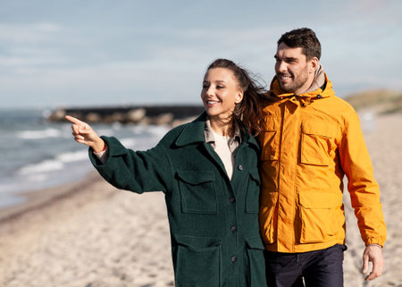 couple walking along autumn beach
