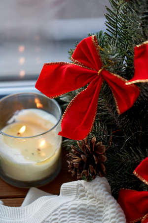 christmas wreath and candle on window sill at homeの写真素材