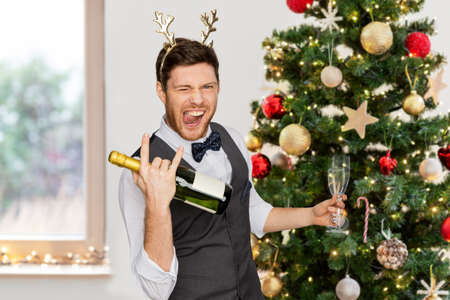 man with bottle of champagne at christmas partyの写真素材