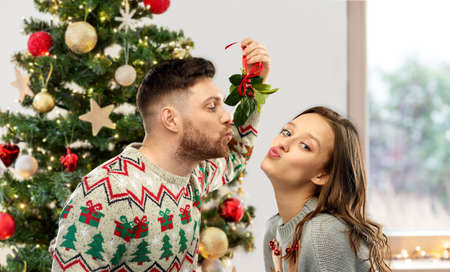 couple kissing under the mistletoe on christmasの写真素材