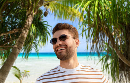 young man in sunglasses over exotic beachの写真素材