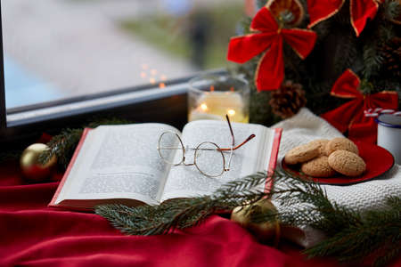 close up of open book and glasses on christmasの写真素材