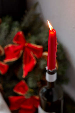 red christmas candle burning in wine bottleの写真素材