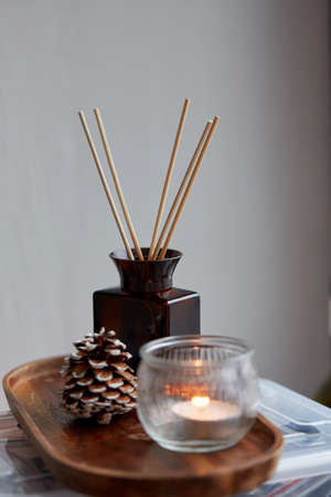 aroma reed diffuser, pine cone and candle at homeの写真素材