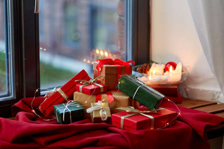 christmas gifts on red tablecloth on window sillの写真素材