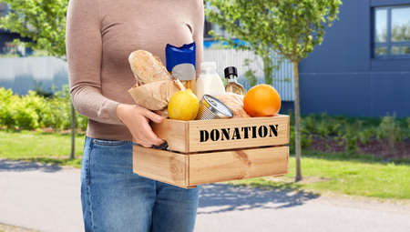 woman with food donation in wooden box on streetの写真素材