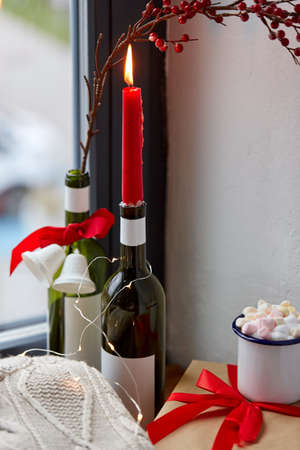 red christmas candle burning in wine bottleの写真素材