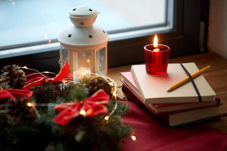 christmas wreath, books, candle, lantern on windowの写真素材