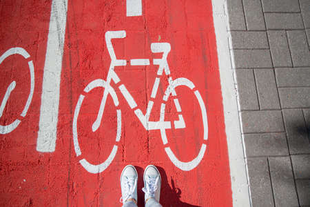 feet in gumshoes on bike lane or road for bicyclesの写真素材