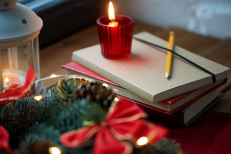 christmas wreath, books, candle, lantern on windowの写真素材