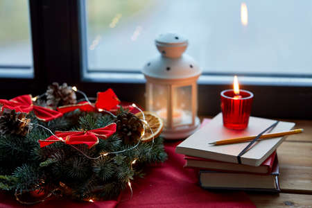 christmas wreath, books, candle, lantern on windowの写真素材