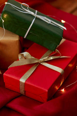 christmas gifts with garland on red tablecloth