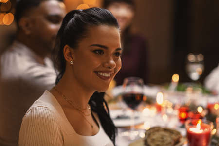 happy woman having christmas dinner with friendsの写真素材