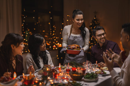 happy friends having christmas dinner at homeの写真素材