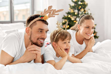 family in bed in christmas morningの写真素材