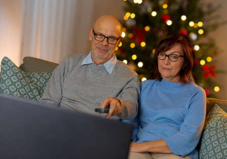 senior couple watching tv at home on christmas