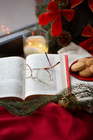 close up of open book and glasses on christmasの写真素材