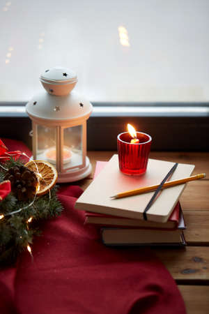 christmas wreath, books, candle, lantern on windowの写真素材