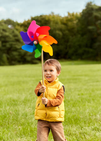 happy little boy with pinwheel playing at parkの写真素材
