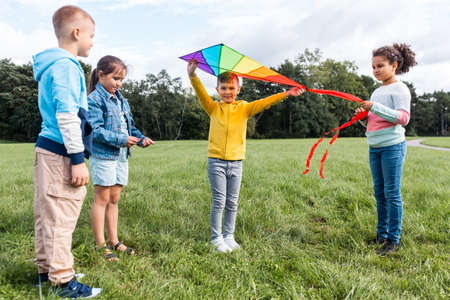 happy kids with kite playing at parkの写真素材