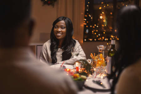 happy woman with friends having christmas dinnerの写真素材