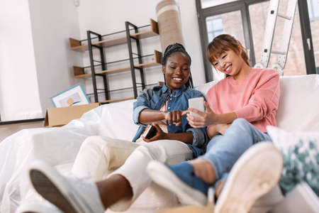 women with smartphones moving into new home