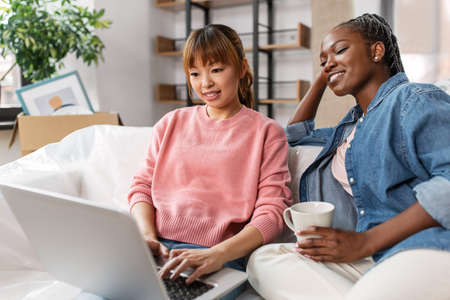 women using laptop and moving to new homeの写真素材