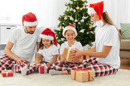 happy family opening christmas gifts at homeの写真素材