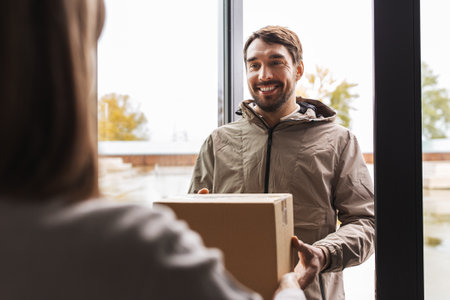 delivery man giving parcel box to customer at homeの写真素材