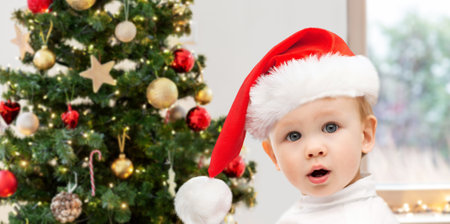 lovely baby boy over christmas tree at homeの写真素材