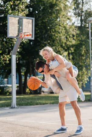 happy couple having fun on basketball playgroundの写真素材