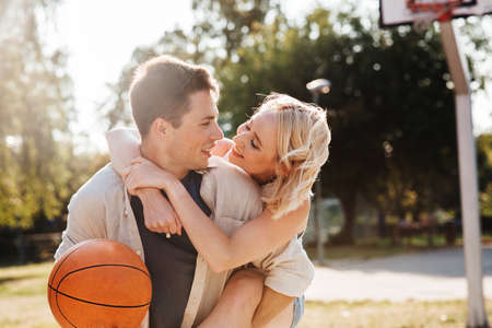 happy couple having fun on basketball playgroundの写真素材