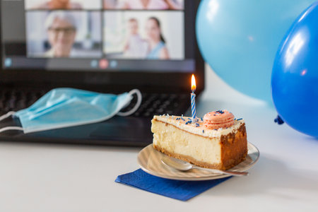 birthday cake and laptop with video call on screen