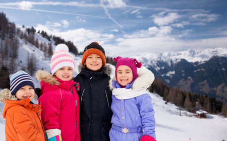 happy little kids in winter clothes outdoorsの写真素材
